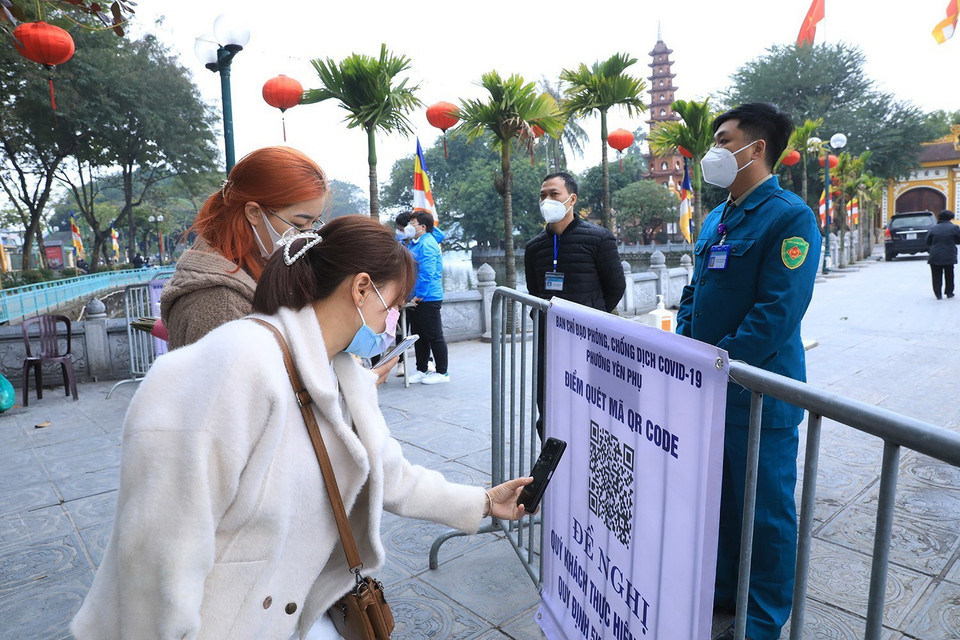 Người dân phải quét mã QR, khai báo y tế trước khi vào chùa Trấn Quốc, quận Tây Hồ, Hà Nội. (Ảnh: Tuấn Anh/TTXVN)