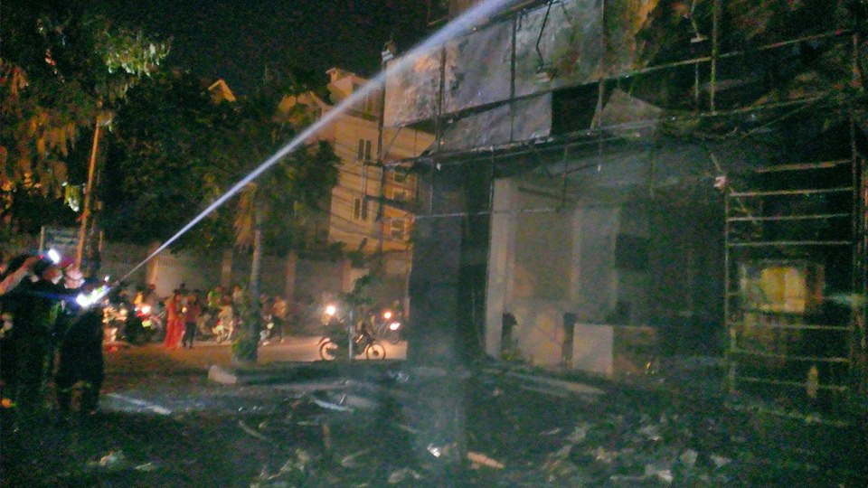 Lực lượng cảnh sát phòng cháy chữa cháy nỗ lực dập tắt ngọn lửa ở mặt tiền tòa nhà. (Ảnh: Việt Phương/Vietnam+)