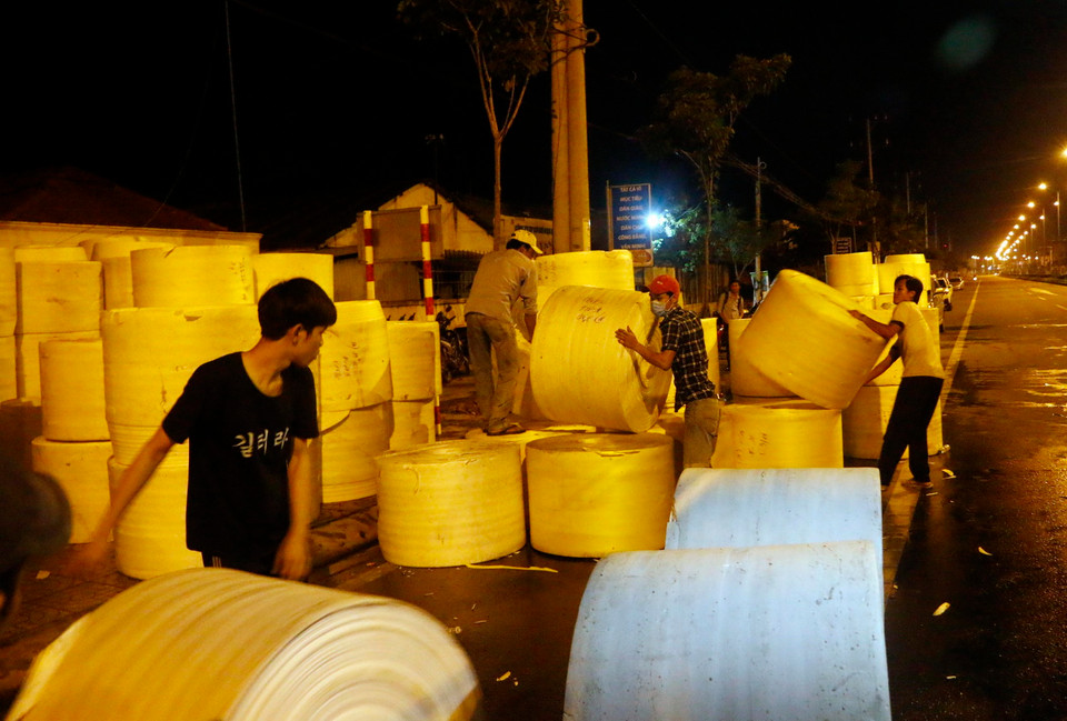 Công nhân Công ty Kim Ngọc Long thu dọn tài sản sau vụ cháy. (Ảnh: Thanh Liêm/TTXVN)