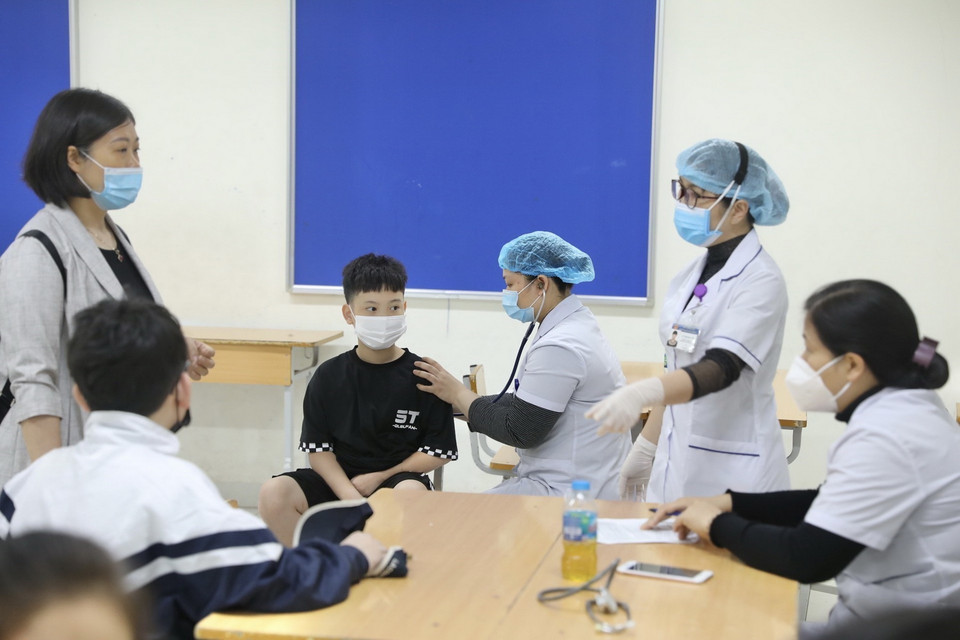 Khám sàng lọc cho các em trước tiêm. (Ảnh: Minh Quyết/TTXVN)