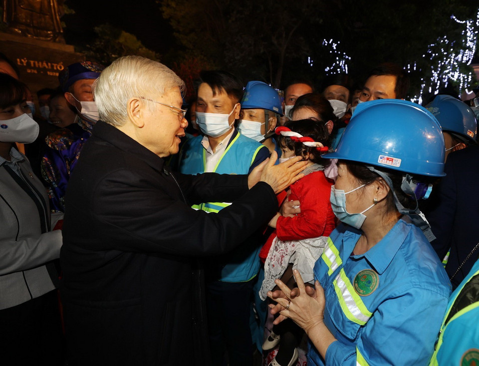  Tổng Bí thư, Chủ tịch nước Nguyễn Phú Trọng với cháu bé và người lao động Thủ đô tại Tượng đài Lý Thái Tổ. (Ảnh : Trí Dũng/TTXVN)