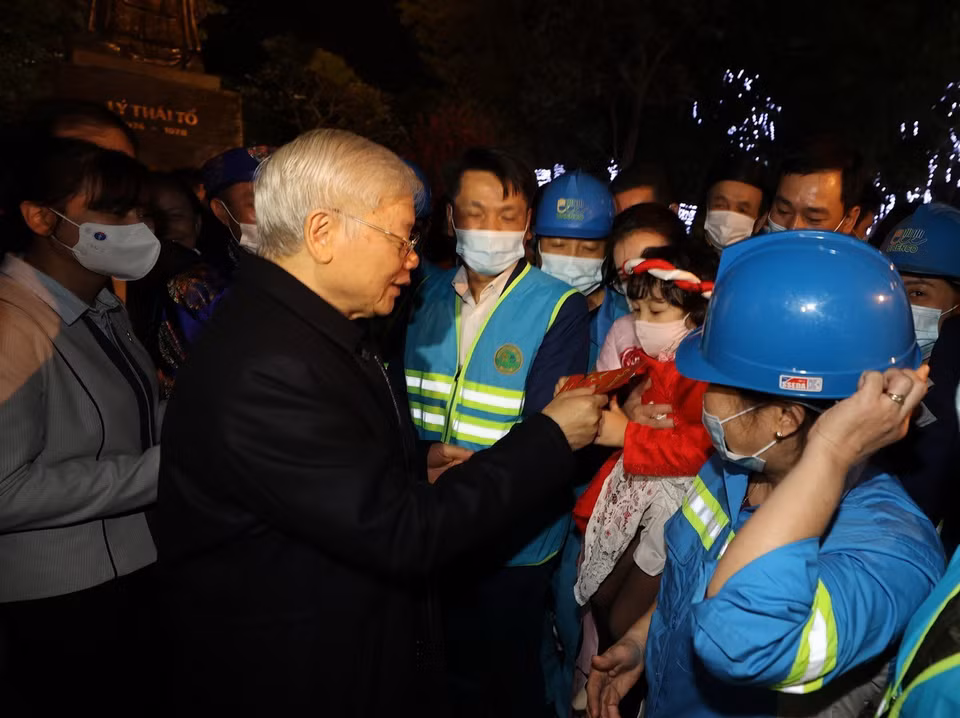 Tổng Bí thư, Chủ tịch nước Nguyễn Phú Trọng với cháu bé và người lao động Thủ đô tại Tượng đài Lý Thái Tổ. (Ảnh : Trí Dũng/TTXVN)