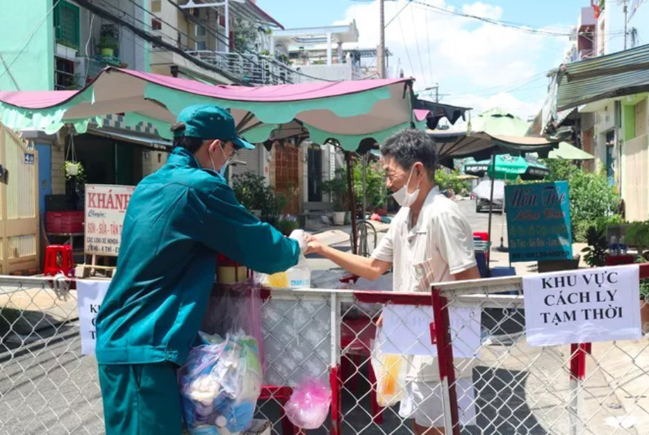 Phát thực phẩm, nhu yếu phẩm cho người dân trong khu vực bị phong tỏa. (Ảnh: TTXVN phát)