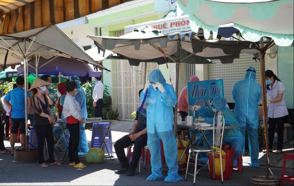 Lực lượng y tế tiến hành lấy mẫu xét nghiệm người dân trong hẻm bị phong tỏa. (Ảnh: TTXVN phát)