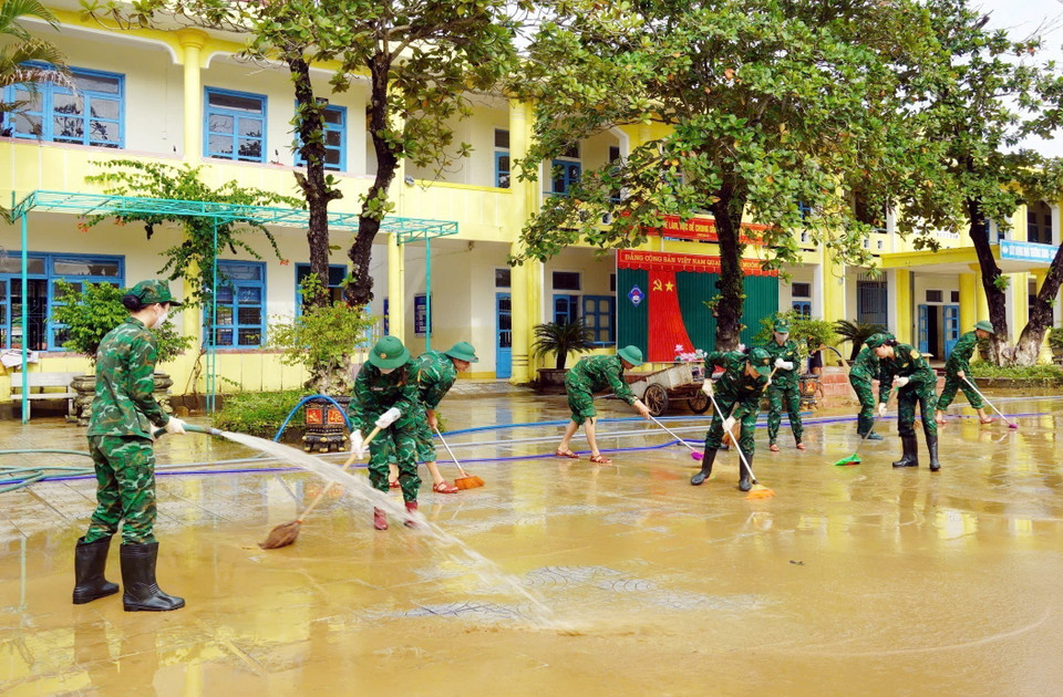 Lực lượng Bộ đội Biên phòng tỉnh Quảng Bình hỗ trợ các giáo viên tổng dọn vệ sinh trường mầm non xã Phong Thủy, huyện Lệ Thủy. (Ảnh: TTXVN phát)
