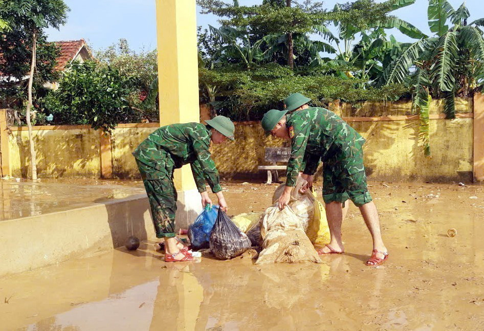Lực lượng Bộ đội Biên phòng tỉnh Quảng Bình thu gom rác, vệ sinh môi trường tại trường mầm non xã Phong Thủy, huyện Lệ Thủy. (Ảnh: TTXVN phát)