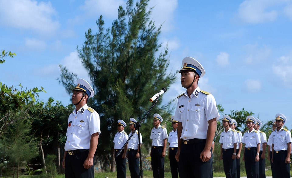 Thượng úy Mai Xuân Hải (bên phải ảnh) tuyên thệ 10 lời thề danh dự của quân nhân Quân đội nhân dân Việt Nam tại lễ chào cờ, duyệt đội ngũ tại đảo Trường Sa Đông (quần đảo Trường Sa). (Ảnh: Hoàng Hùng/TTXVN)