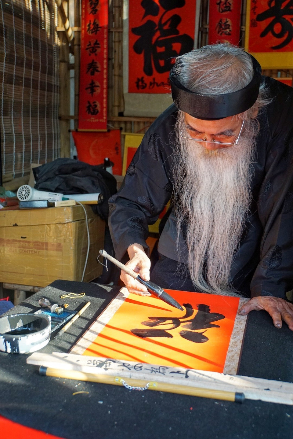 Ông đồ già đang cho chữ tại Văn Miếu-Quốc Tử Giám. (Ảnh: Khánh Hòa/TTXVN phát)