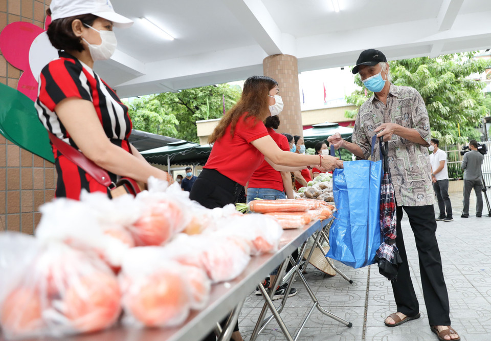 Các gia đình có hoàn cảnh khó khăn, bị ảnh hưởng bởi dịch COVID-19 tại quận Hai Bà Trưng (Hà Nội) đi Chợ nhân đạo. (Ảnh: Thanh Tùng/TTXVN)