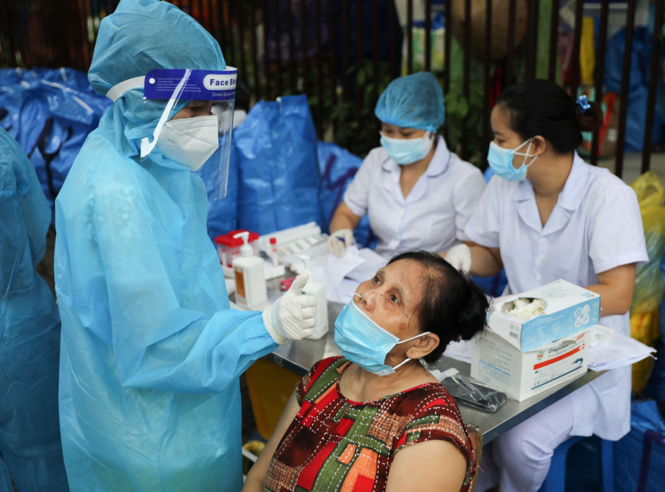 Lấy mẫu test nhanh cho người dân đến nhận quà hỗ trợ tại Chợ nhân đạo. (Ảnh: Thanh Tùng/TTXVN)