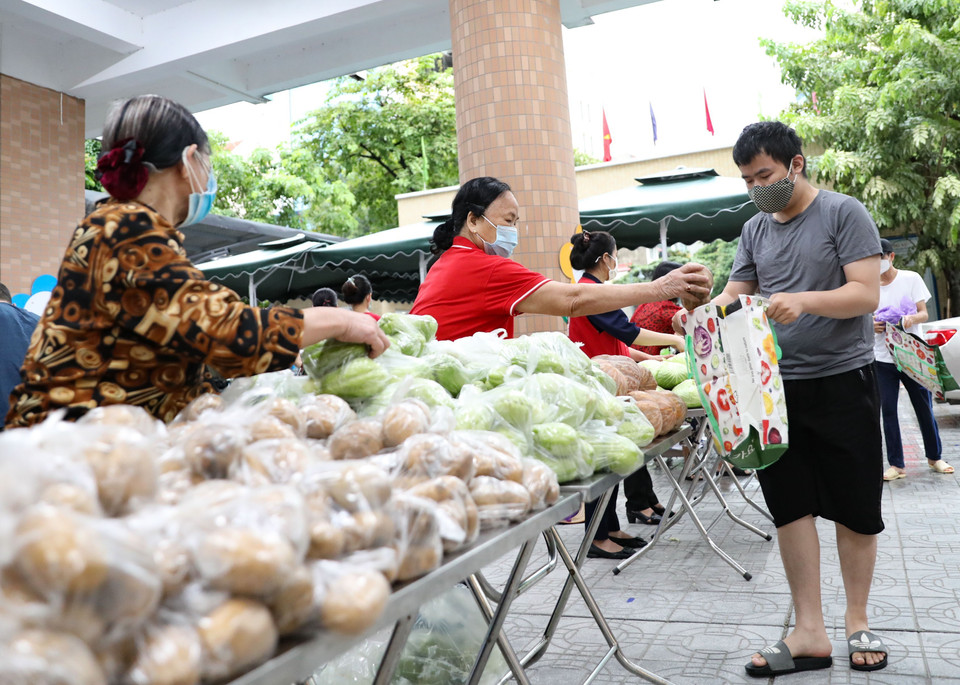 Các gia đình có hoàn cảnh khó khăn, bị ảnh hưởng bởi dịch COVID-19 tại quận Hai Bà Trưng (Hà Nội) đi Chợ nhân đạo. (Ảnh: Thanh Tùng/TTXVN)