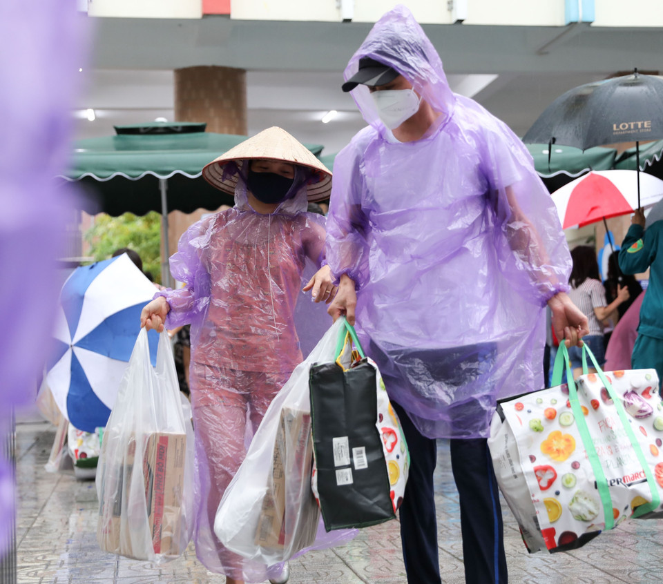 Mặc dù trời mưa to nhưng người người dân vẫn phấn khởi đến Chợ nhân đạo. (Ảnh: Thanh Tùng/TTXVN)