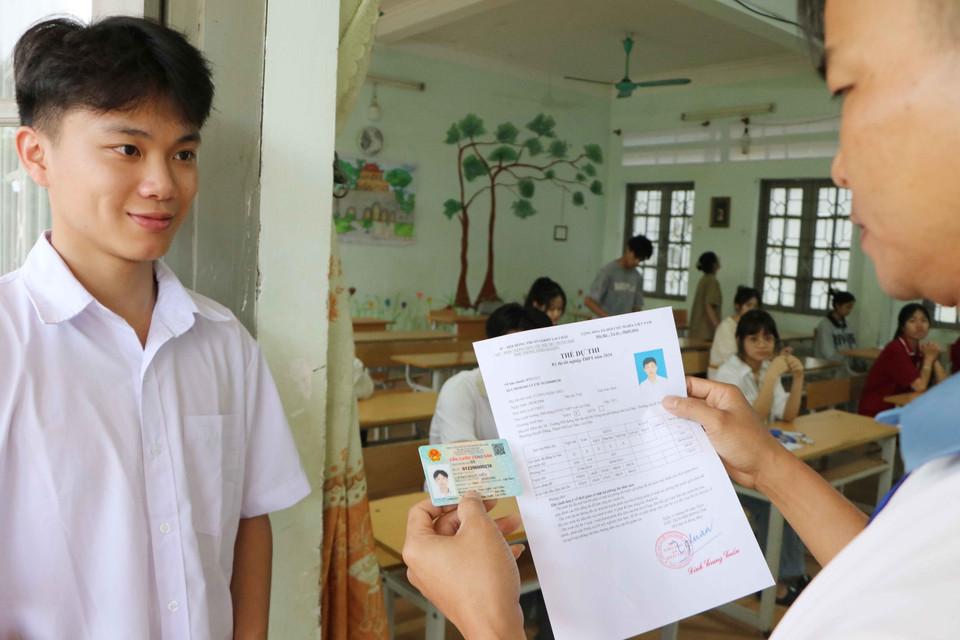 Giám thị phòng thi kiểm tra giấy tờ của các thí sinh trước khi vào phòng thi tại Trường Phổ thông Dân tộc nội trú THPT tỉnh Lai Châu. (Ảnh: Nguyễn Oanh/TTXVN)