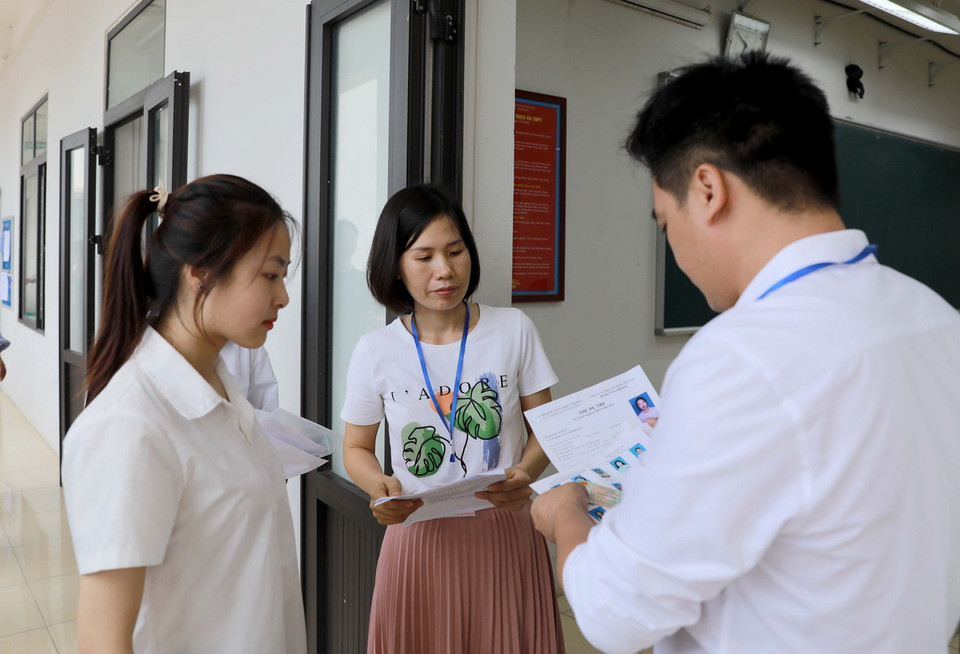 Giám thị kiểm tra thí sinh trước khi vào phòng thi tại Trường THPT Trần Hưng Đạo, huyện Tam Dương. (Ảnh: Hoàng Hùng/TTXVN)