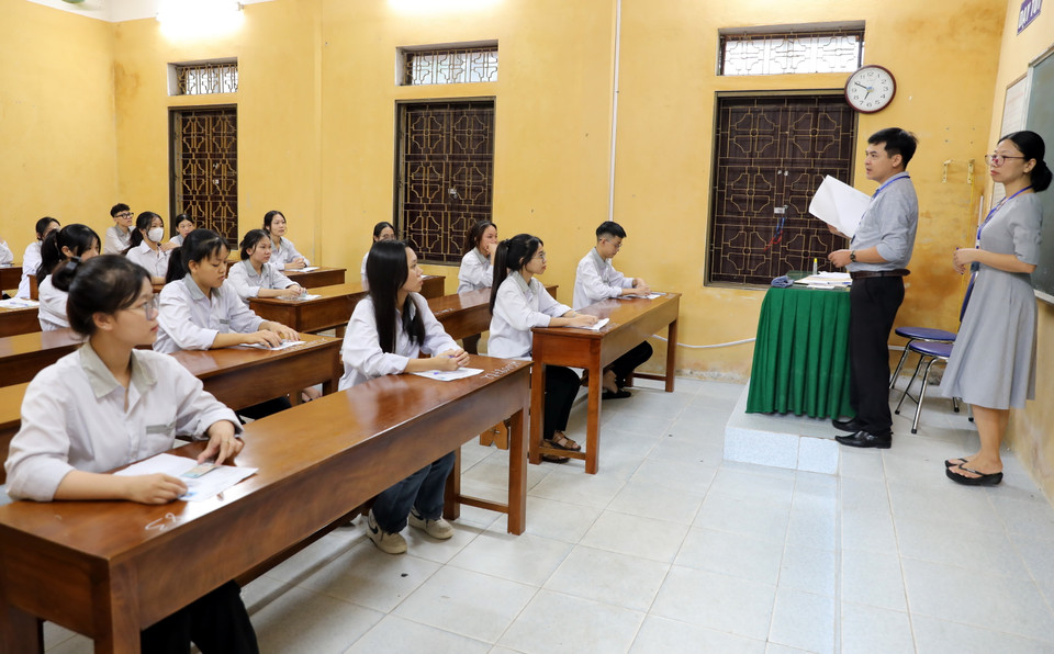 Cán bộ nhắc nhở quy chế thi cho thí sinh tại điểm thi Trường THPT Nam Trực, huyện Nam Trực. (Ảnh: Nguyễn Lành/TTXVN)