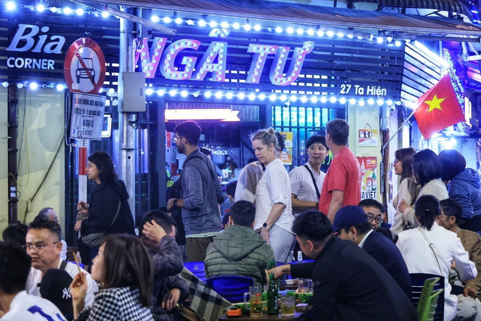 Nhiều du khách Quốc tế phải len lỏi qua các hàng quán khi đi trên con phố Tạ Hiện đông đúc. (Ảnh: Tuấn Anh/TTXVN)