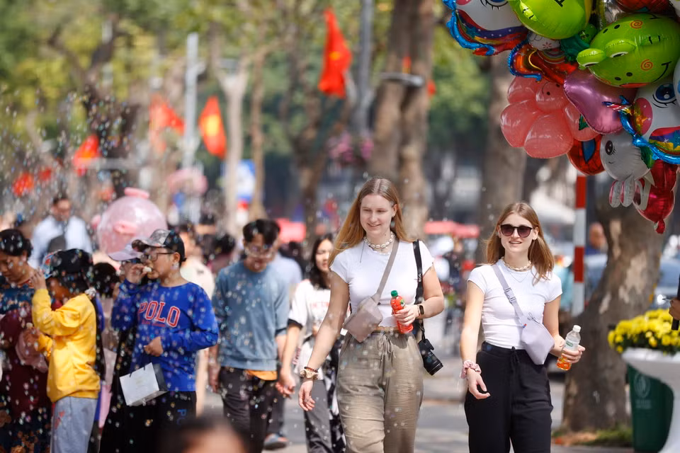 Du khách Quốc tế tham quan hồ Hoàn Kiếm dịp Tết Nguyên đán Giáp Thìn 2024. (Ảnh: Minh Quyết/TTXVN)