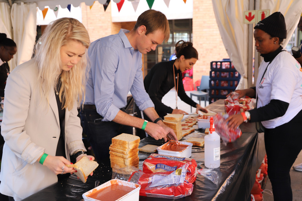 Các tình nguyện viên làm 7.000 chiếc bánh mỳ sandwich tại Quảng trường Nelson Mandela, Johannesburg. (Ảnh: Hồng Minh/TTXVN)
