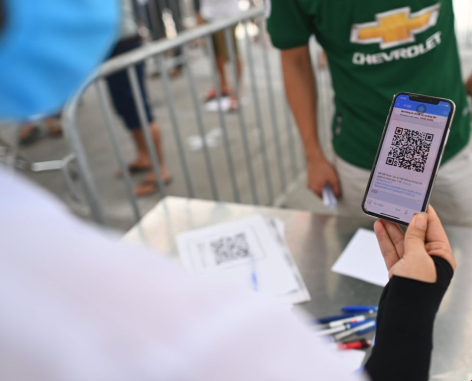 Người đã khai báo y tế qua mã QR sẽ cung cấp thông tin để nhân viên y tế kiểm tra. (Ảnh: Thành Đạt/TTXVN)