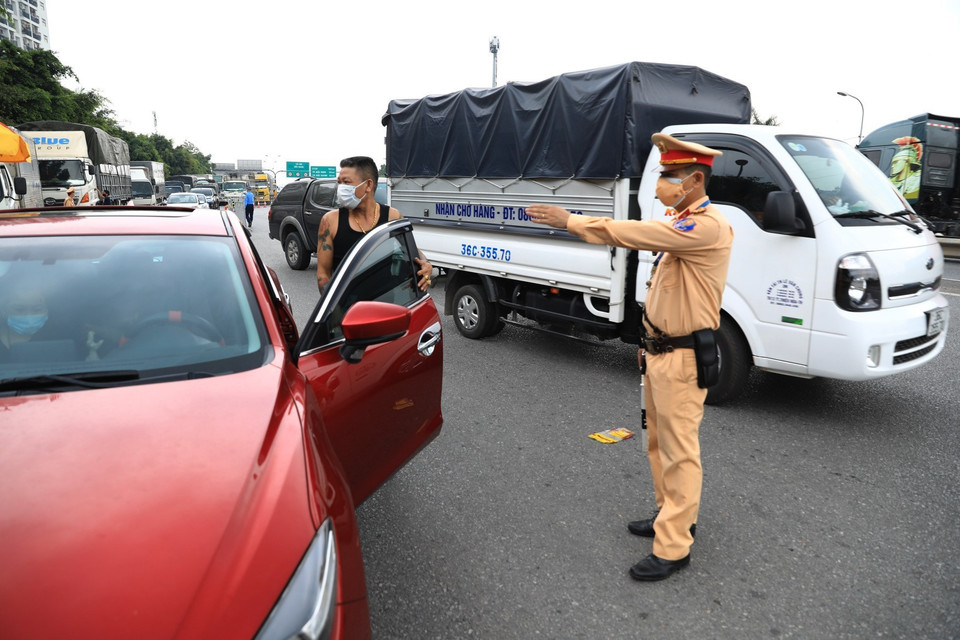 Lực lượng chức năng tại chốt kiểm tra cao tốc Hà Nội-Lạng Sơn (chân cầu Phù Đổng) yêu cầu các tài xế xuống xe kiểm tra và khai báo y tế. Ảnh: Thành Đạt/TTXVN)