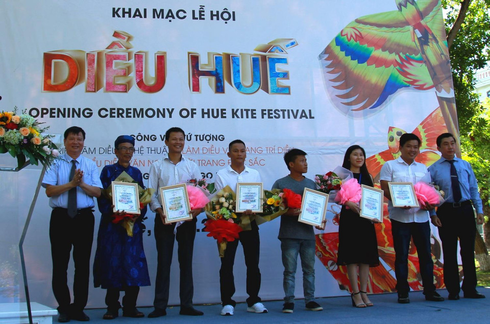 Ban tổ chức trao giấy chứng nhận cho nghệ nhân và nhà tài trợ tham gia lễ hội Diều Huế. (Ảnh: Tường Vi/TTXVN)