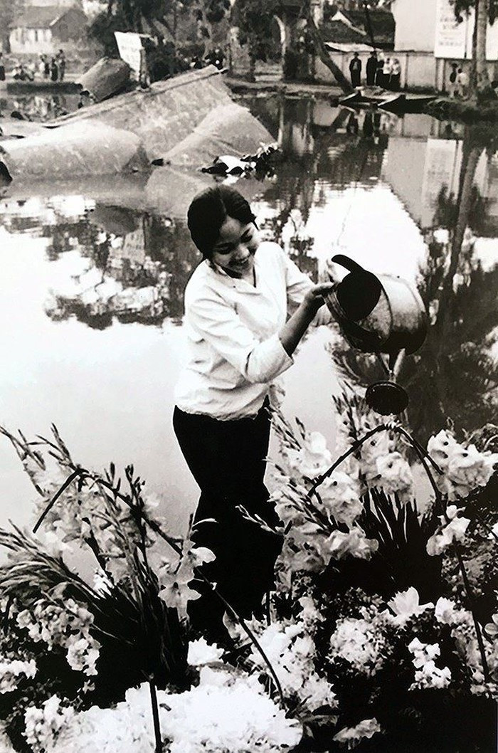 Hình ảnh cô gái tưới hoa bên xác chiếc máy bay Mỹ B-52 rơi ở hồ Hữu Tiệp, làng Ngọc Hà (Hà Nội) tô điểm thêm cho chiến thắng của quân và dân Hà Nội trong chiến thắng lịch sử "Hà Nội - Điện Biên Phủ trên không" tháng 12/1972. (Ảnh: Văn Bảo/TTXVN)