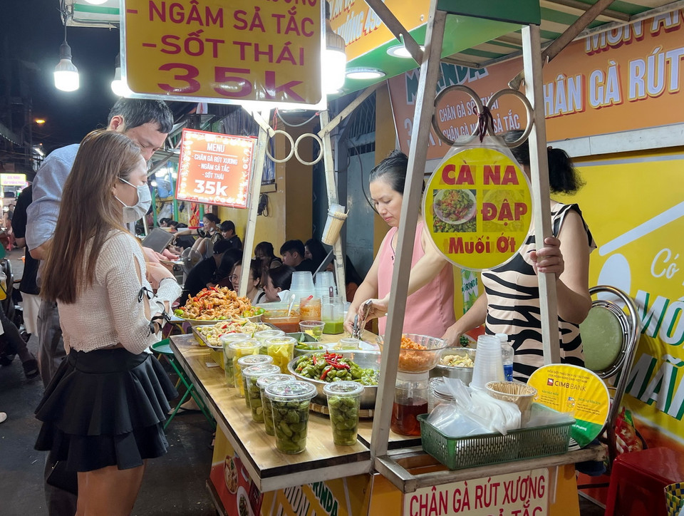 Du khách trải nghiệm phố ẩm thực Hồ Thị Kỷ, quận 10. (Ảnh: Thu Hương/TTXVN)