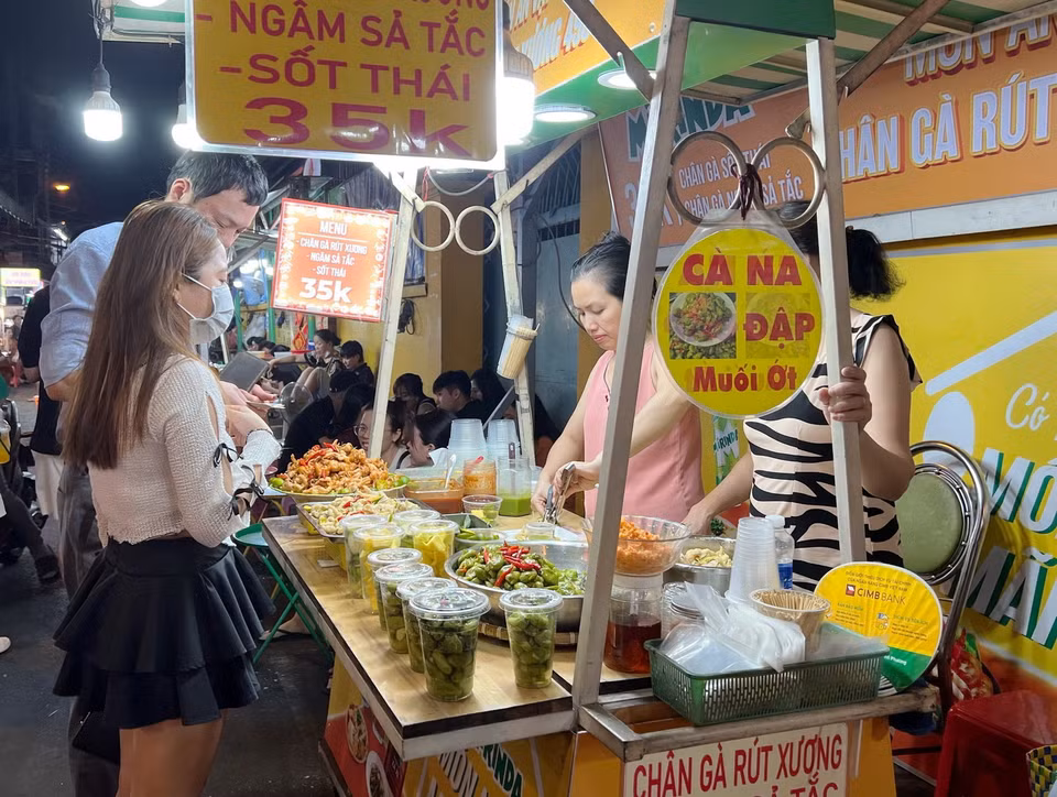 Du khách trải nghiệm phố ẩm thực Hồ Thị Kỷ, quận 10. (Ảnh: Thu Hương/TTXVN)