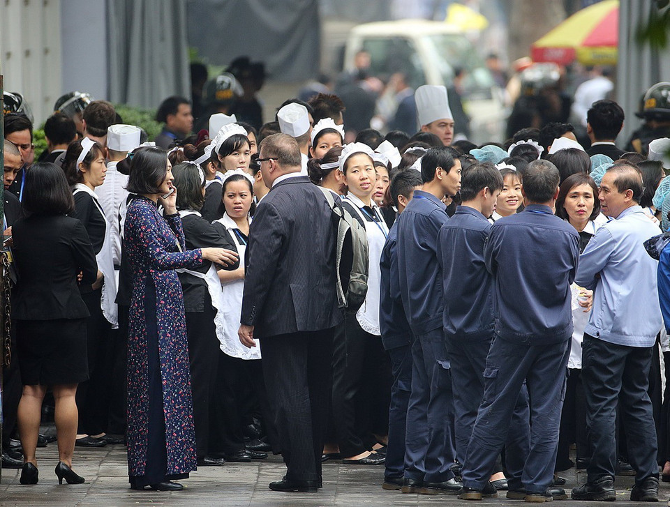 Nhân viên khách sạn Metropole dời ra bên ngoài khu vực cổng phụ trên phố Lý Thái Tổ theo yêu cầu của đoàn Triều Tiên. (Ảnh: Dương Giang/TTXVN)