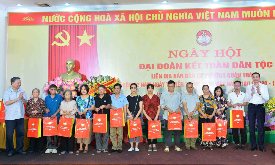 Đại tướng Tô Lâm, Bộ trưởng Bộ Công an, và Phó Chủ tịch Ủy ban Trung ương Mặt trận Tổ quốc Việt Nam Phùng Khánh Tài tặng quà cho các hộ gia đình có hoàn cảnh khó khăn. (Ảnh: Minh Đức/TTXVN)