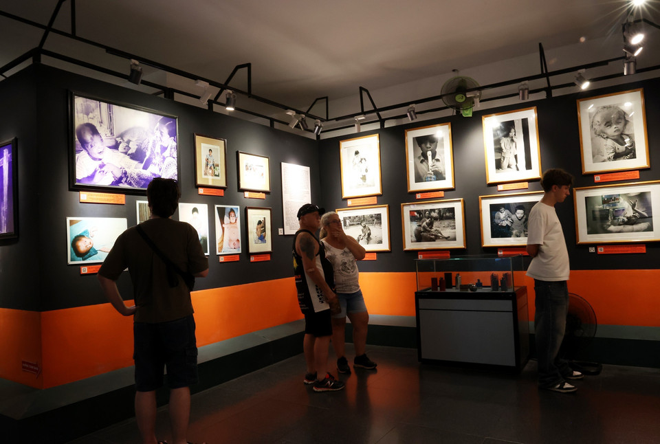 Khách quốc tế tìm hiểu nỗi đau da cam tại Bảo tàng Chứng tích chiến tranh. (Ảnh: Hồng Đạt/TTXVN)