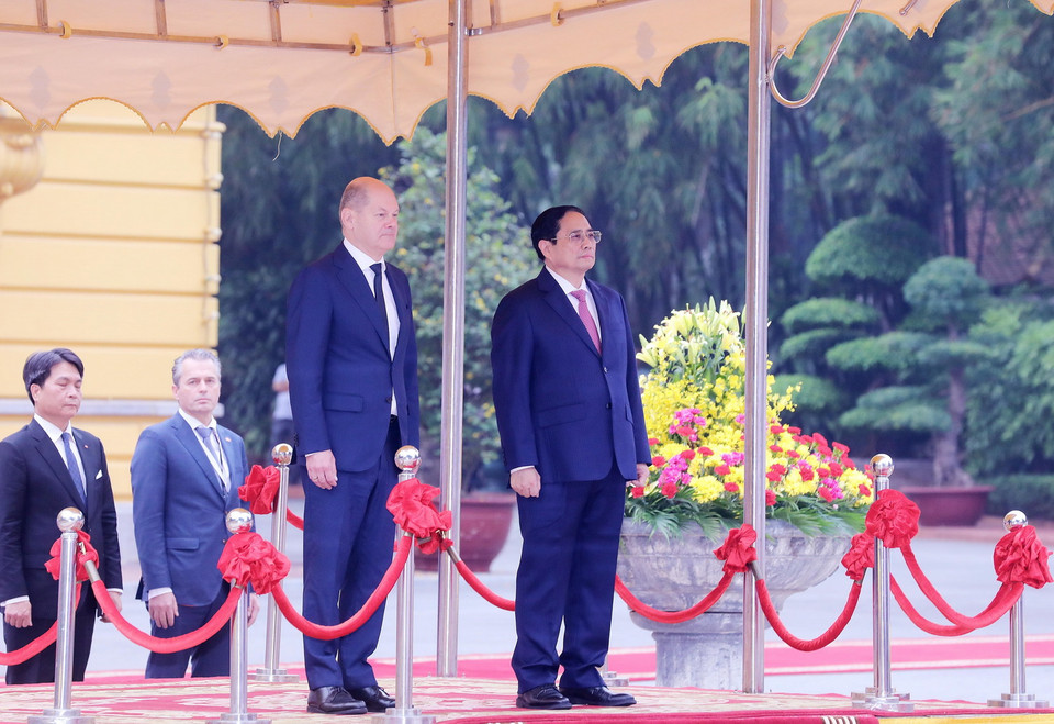 Thủ tướng Phạm Minh Chính và Thủ tướng Đức Olaf Scholz trên bục danh dự, nghe quân nhạc cử Quốc thiều hai nước. Ảnh: Lâm Khánh - TTXVN