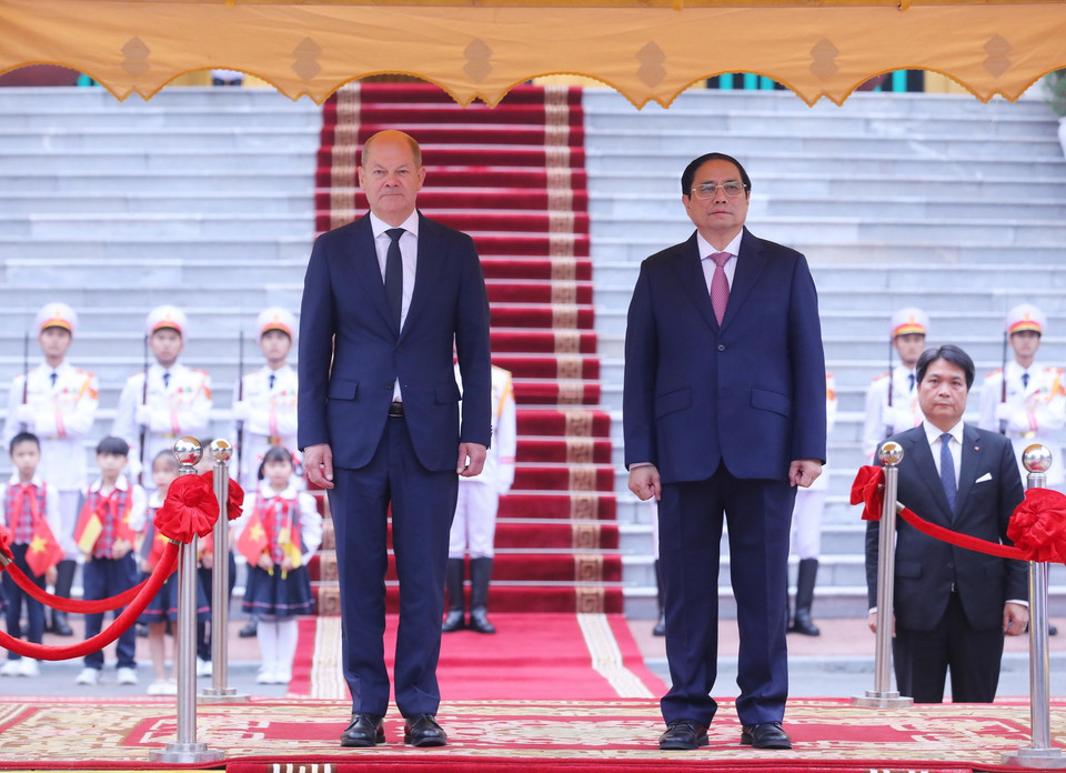 Thủ tướng Phạm Minh Chính và Thủ tướng Đức Olaf Scholz trên bục danh dự, nghe quân nhạc cử Quốc thiều hai nước. Ảnh: Lâm Khánh - TTXVN