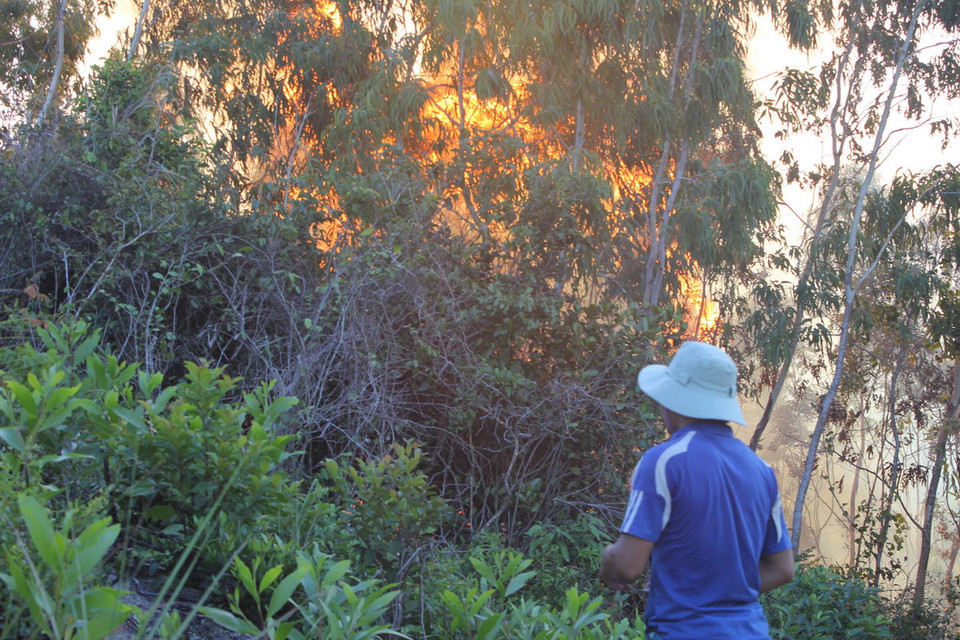 Người dân bất lực nhìn ngọn lửa bốc cháy dữ dội. (Ảnh: Ly Kha/TTXVN)