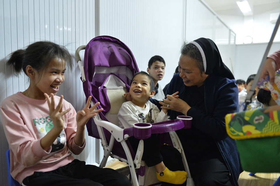 Niềm vui của Nữ tu Catarina Trần Thị Thắm, Tổng phụ trách Dòng mến Thánh giá Phát Diệm với các trẻ em khuyết tật tại Cơ sở Cộng đoàn Nhà mẹ xã Lưu Phương (Kim Sơn, Ninh Bình) thuộc Hội Dòng Mến Thánh giá Phát Diệm. (Ảnh: Minh Đức/TTXVN)