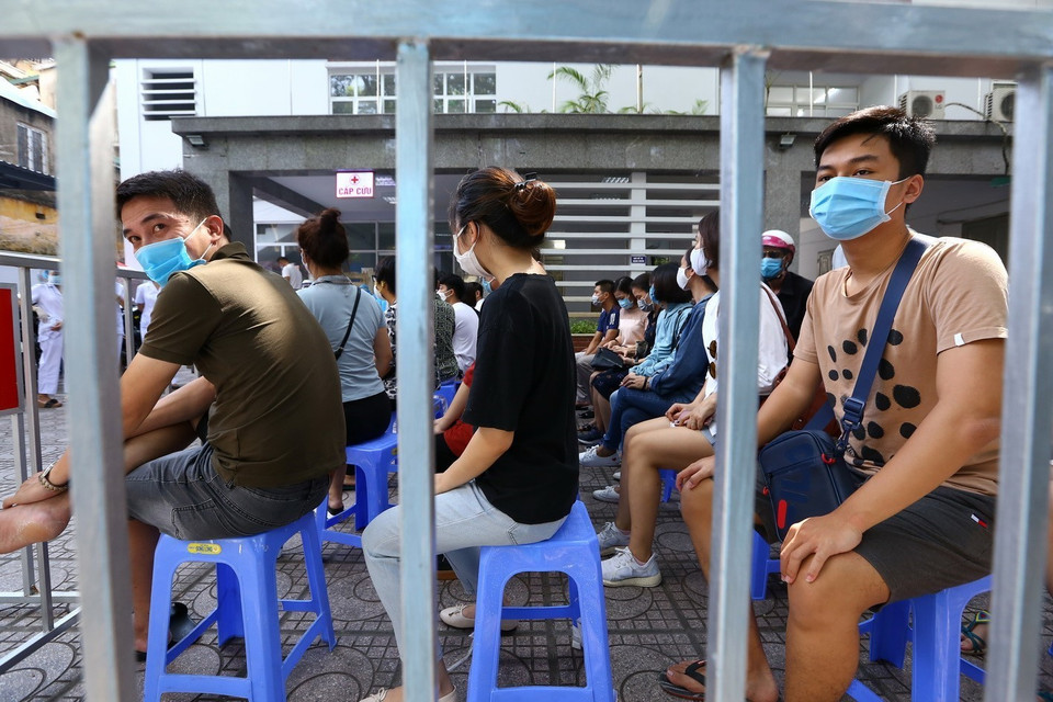 Người dân đến lấy mẫu được bố trí ngồi chờ theo khu vực quy định. (Ảnh: Minh Quyết/TTXVN)