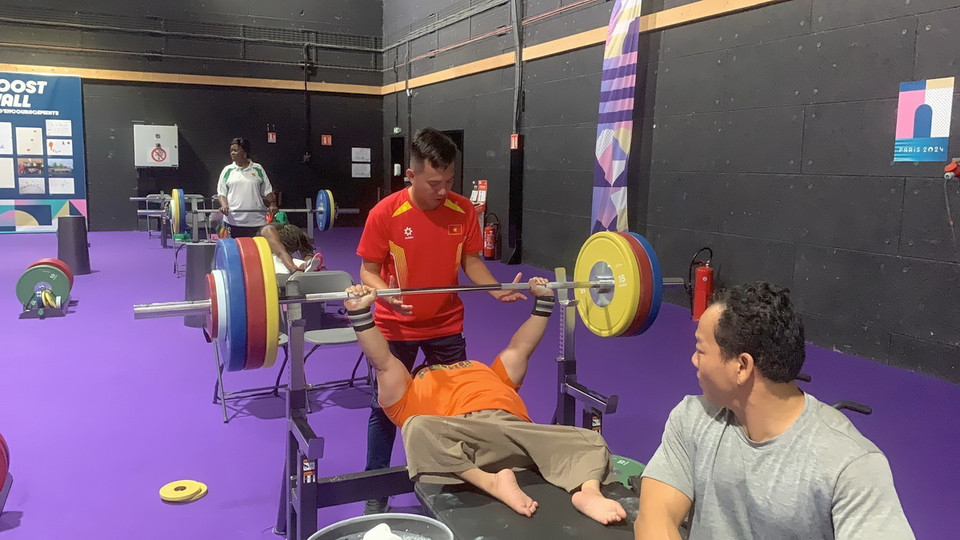 Các vận động viên cử tạ Lê Văn Công và Nguyễn Bình An trong giờ tập với huấn luyện viên Lê Quang Thái. (Ảnh: TTXVN phát)