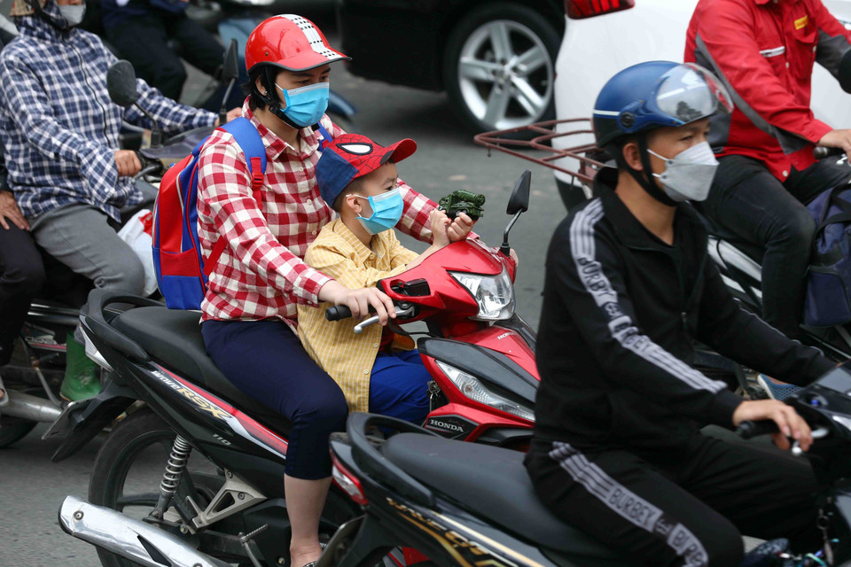 Một trẻ mầm non được mẹ đưa tới trường sau thời gian dài nghỉ học do ảnh hưởng của dịch COVID-19. (Ảnh: Phạm Kiên/TTXVN)