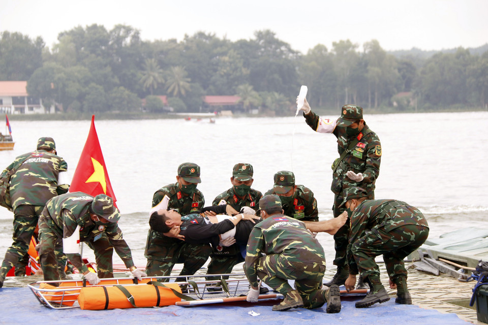Lực lượng quân y Lào và Việt Nam phối hợp đưa người dân đi cấp cứu trong một tình huống giả định tại buổi diễn tập. (Ảnh: Phạm Kiên/TTXVN)