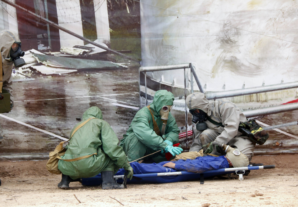 Lực lượng phòng hóa của Việt Nam cứu người dân bị ảnh hưởng của rò rỉ khí độc trong một tình huống giả định tại buổi diễn tập. (Ảnh: Phạm Kiên/TTXVN)