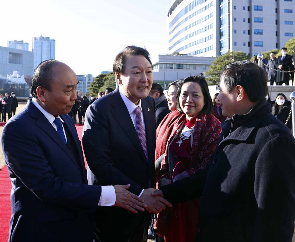 Chủ tịch nước Nguyễn Xuân Phúc giới thiệu các thành viên Đoàn đại biểu cấp cao Việt Nam với Tổng thống Hàn Quốc Yoon Suk-yeol. (Ảnh: Thống Nhất/TTXVN)