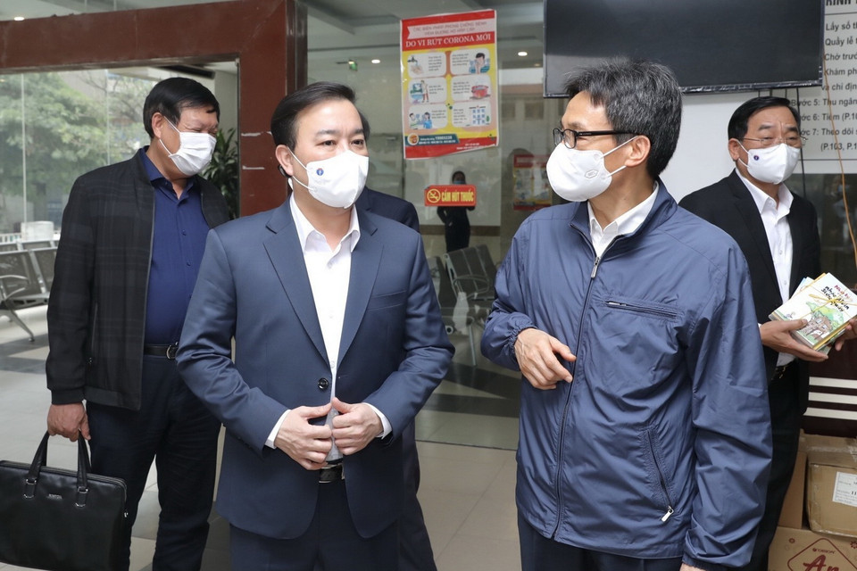 Phó Thủ tướng Vũ Đức Đam và các đại biểu kiểm tra công tác làm xét nghiệm COVID-19 tại CDC Hà Nội. (Ảnh: Minh Quyết/TTXVN)