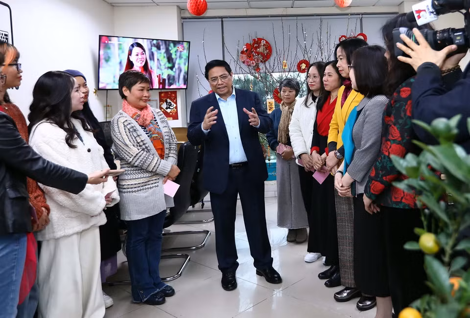 Thủ tướng Phạm Minh Chính động viên chúc mừng năm mới phóng viên, biên tập viên Ban Biên tập Tin Thế giới. (Ảnh: Huy Hùng/TTXVN)