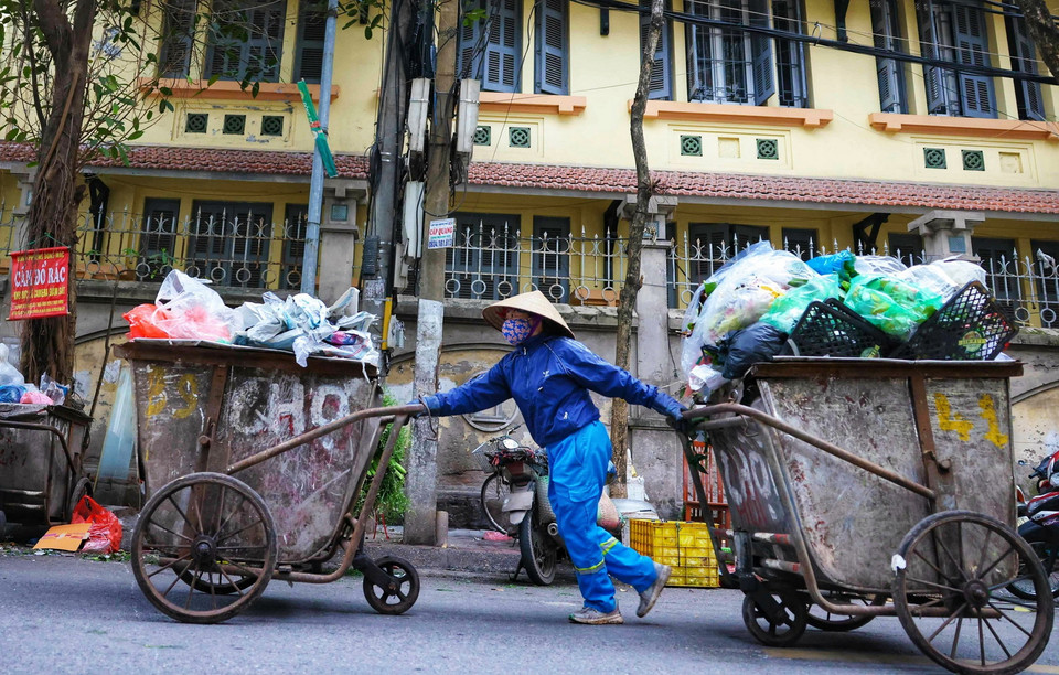 Lượng rác trong dịp Tết Nguyên đán tăng cao khiến công nhân vệ sinh thu dọn rất vất vả. (Ảnh: Thanh Tùng/TTXVN)