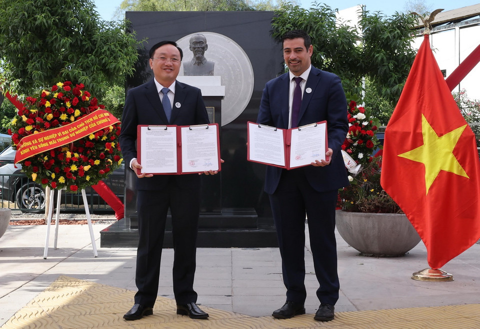 Đại diện huyện Nam Đàn (tỉnh Nghệ An) và quận Cerro Navia trao văn kiện hợp tác. (Ảnh: Lâm ﻿ Khánh/TTXVN)