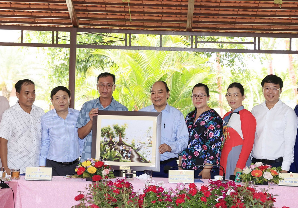 Chủ tịch nước Nguyễn Xuân Phúc tặng quà lưu niệm cho Hội quán “Cùng nhau làm du lịch.” (Ảnh: Thống Nhất/TTXVN) 