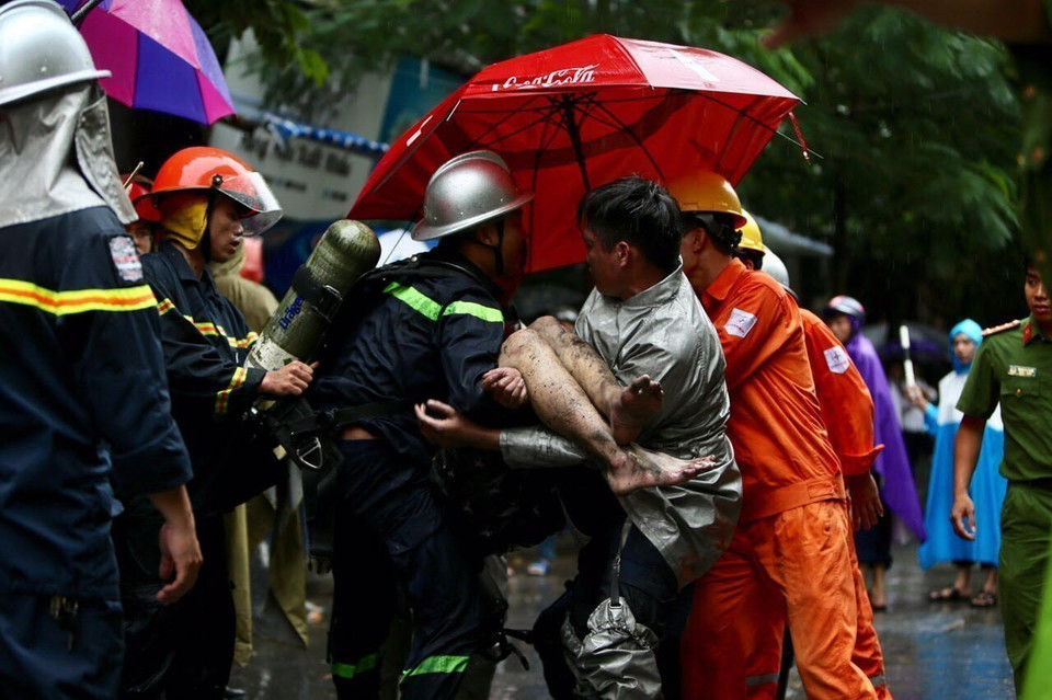 Lực lượng cứu hỏa đưa nạn nhân cuối cùng được ra khỏi đám cháy tòa nhà 5 tầng số 8, ngõ 12, phố Núi Trúc, Ba Đình, Hà Nội. (Ảnh: Dương Giang/TTXVN)