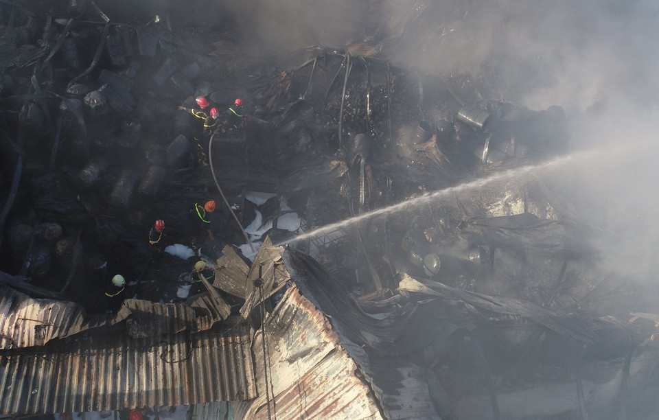 Lực lượng chức năng phun nước ngăn chặn lửa bùng phát trở lại trong vụ cháy tại các kho hàng tại số nhà 27 và 29 đường Hoàng Văn Thái, phường Hòa Minh, quận Liên Chiểu, thành phố Đà Nẵng. (Ảnh: Quốc Dũng/TTXVN)