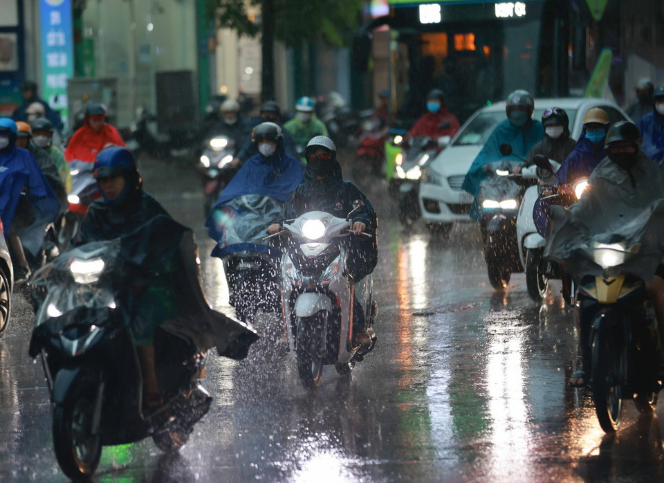 Nhiều phương tiện phải bật đèn chiếu sáng khi tham gia giao thông. (Ảnh: Thanh Tùng/TTXVN)