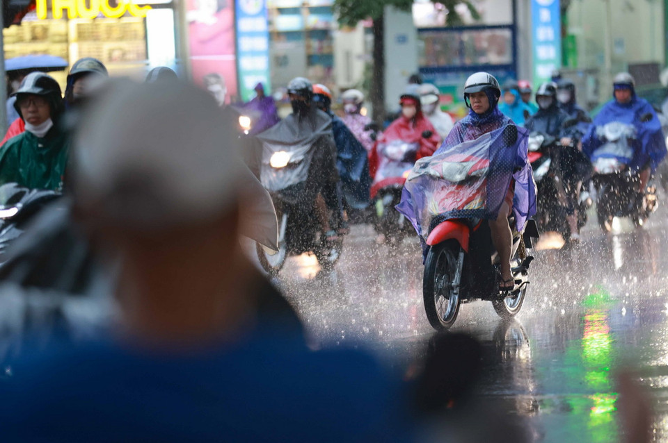 Người dân di chuyển trong mưa vào đầu giờ sáng. (Ảnh: Thanh Tùng/TTXVN)